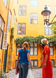 A local guide and tourist standing at a colorful street in Copenhagen, Scandinavia