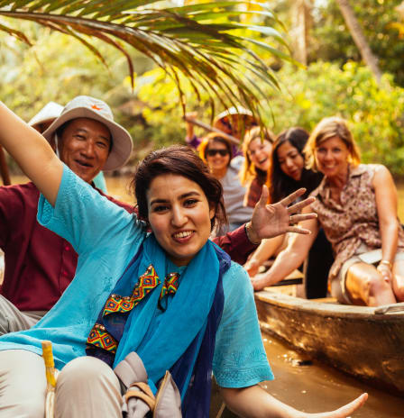 Tourist on a boat with a local guide at the Mekong Delta