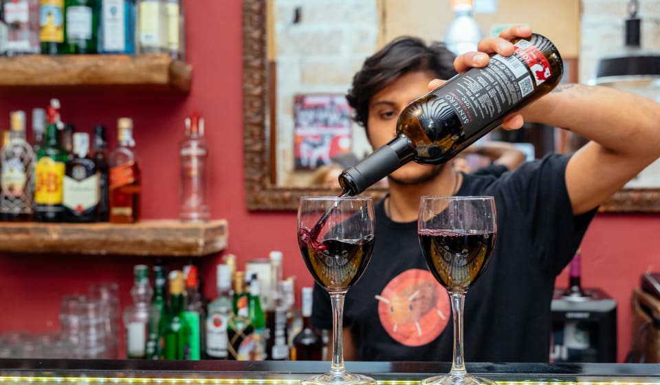 Bartender pouring wine in a glass on the bar