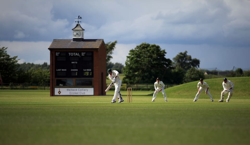 A group of people playing cricket on a field