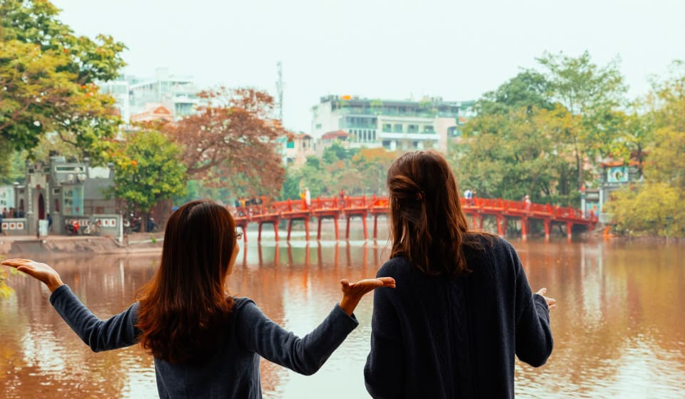 A local guide and tourist at the Long Bien Bridge at the Banana Island