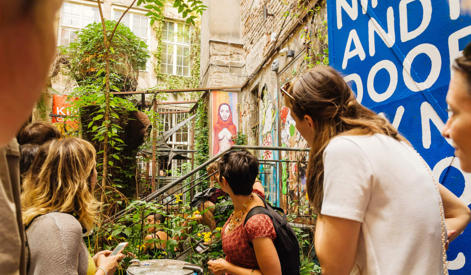 A local guide showing a street art murial in a hip district of Berlin