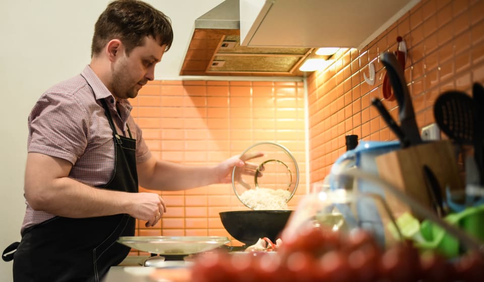 A guy with apron cooking in the kitchen