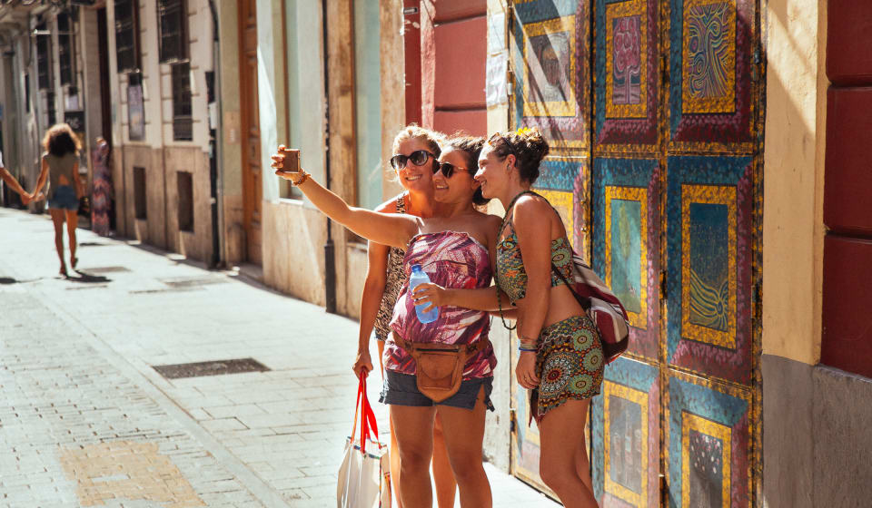 Three ladies taking a selfie in front of a colorful wall in Valencia