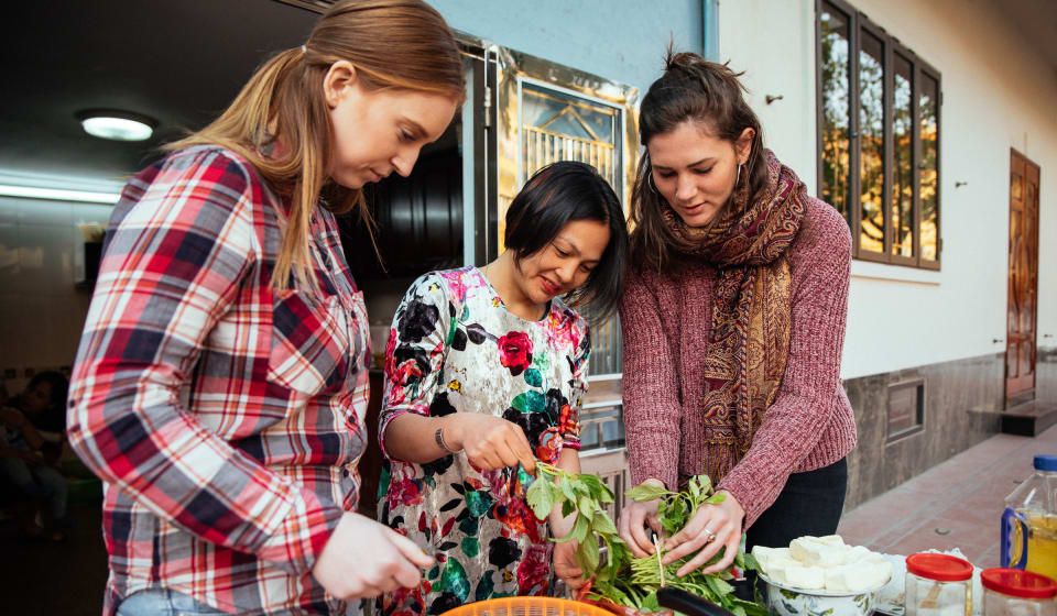 A local guide showing two tourists how cook Vietnamese food in Hanoi