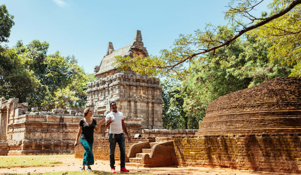 Local guide with a tourist taking a walk on the grounds of Dambulla