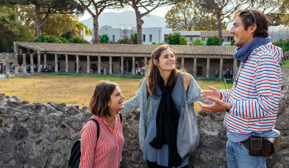 A local with 2 tourists telling a story in Pompeii