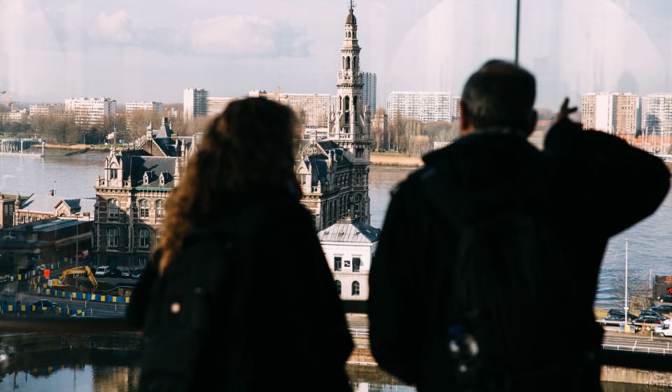 Two people looking through a window to an old building in Antwerp