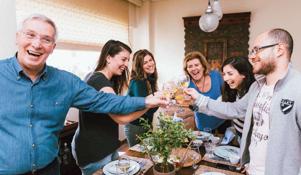 A group of tourists doing a toast in a locals host with Turkish wine in Istanbul