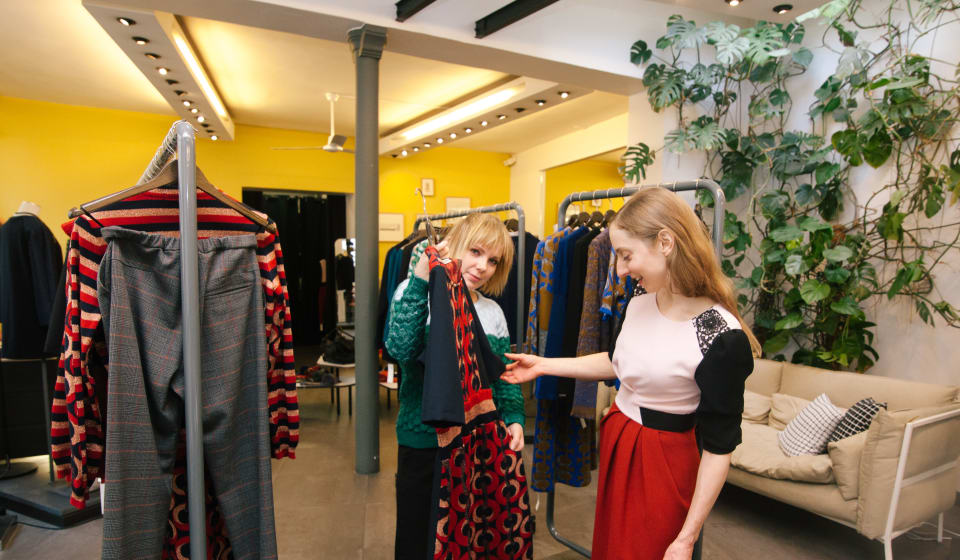 A girl showing a dress to another girl in a Parisian shop