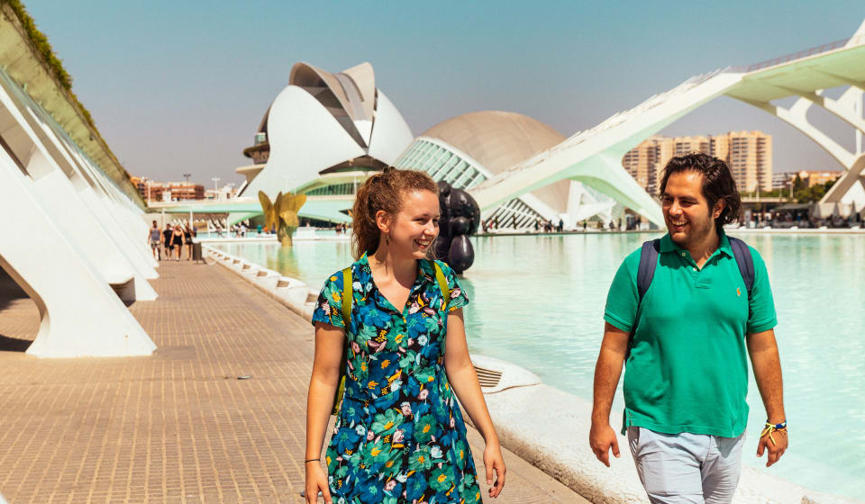 Local guide and a tourist walking next to the water at Ciudad de las Artes y las Ciencias, Valencia