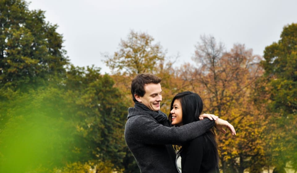 A woman and a man hugging in a park