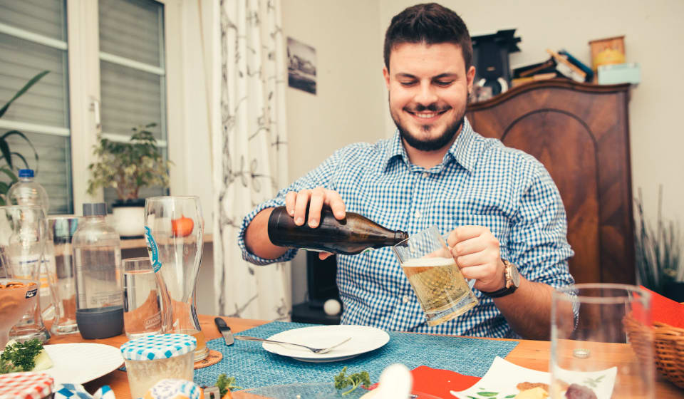 Guy pouring a beer at a table