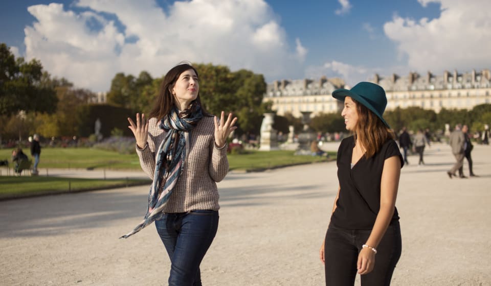 A local guide with a tourist in the gardens of the Louvre