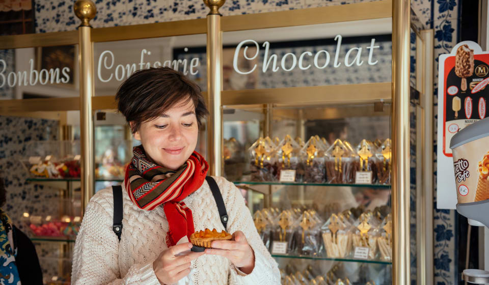 A woman enjoying a pastry in a pastry shop