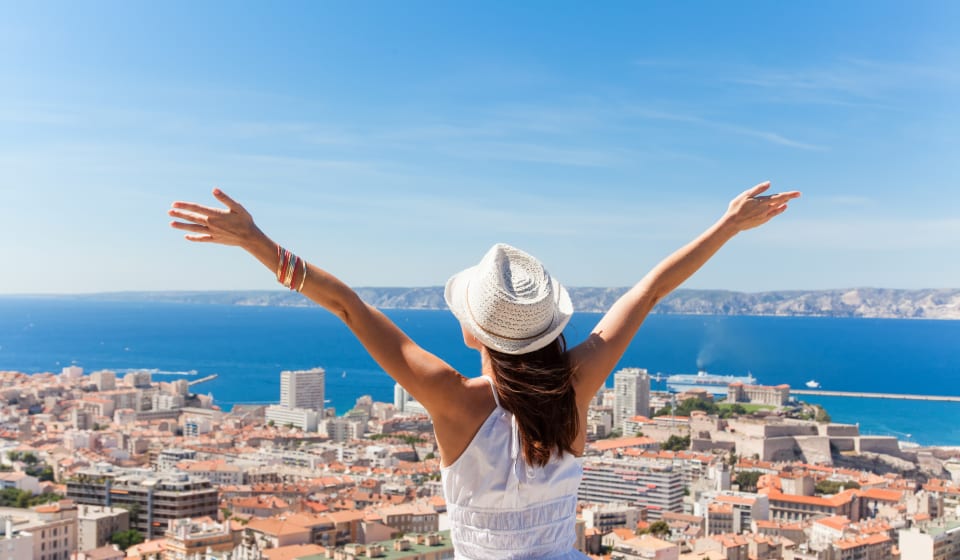 A view over Marseille with a tourist spreading her arms