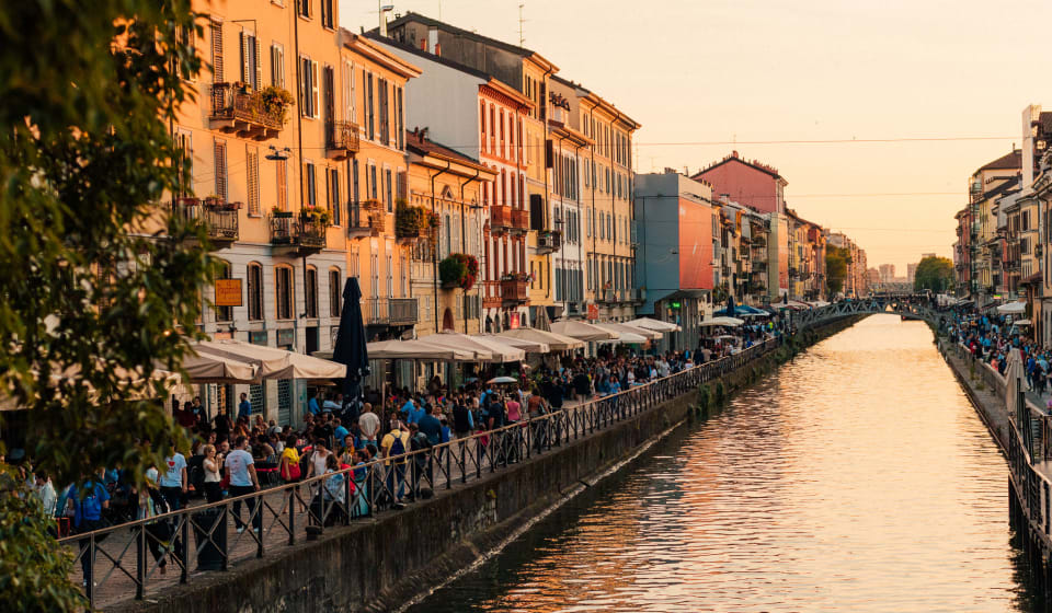A view over the canal in the Navigli district with busy terraces on the side and colorful houses