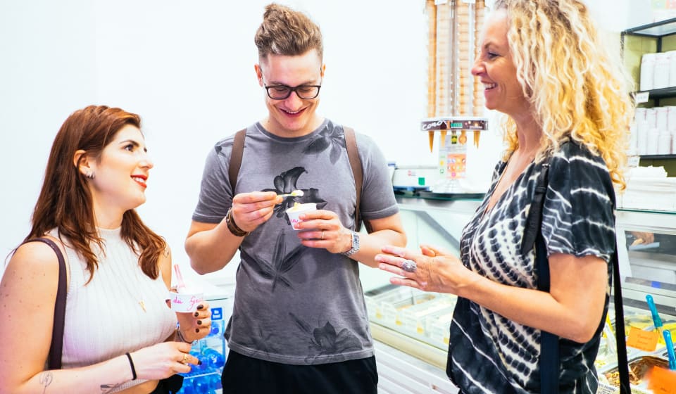 A local guide with two tourists enjoying an ice cream or gelato in Rome