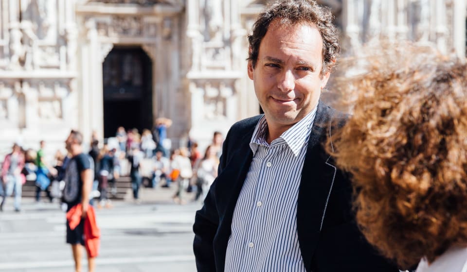 A local guide with a tourist in front of the Duomo in Milan