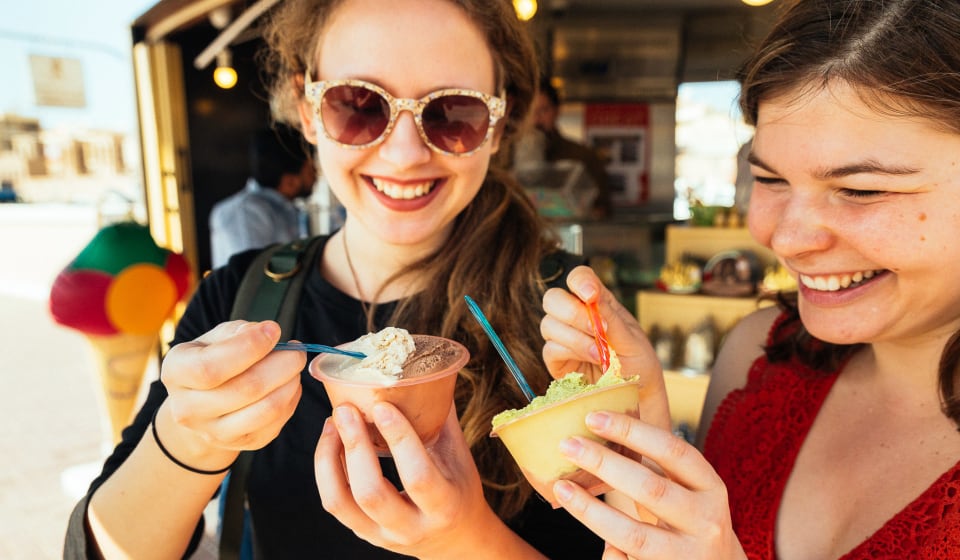 Two girls enjoying each a cup of ice cream