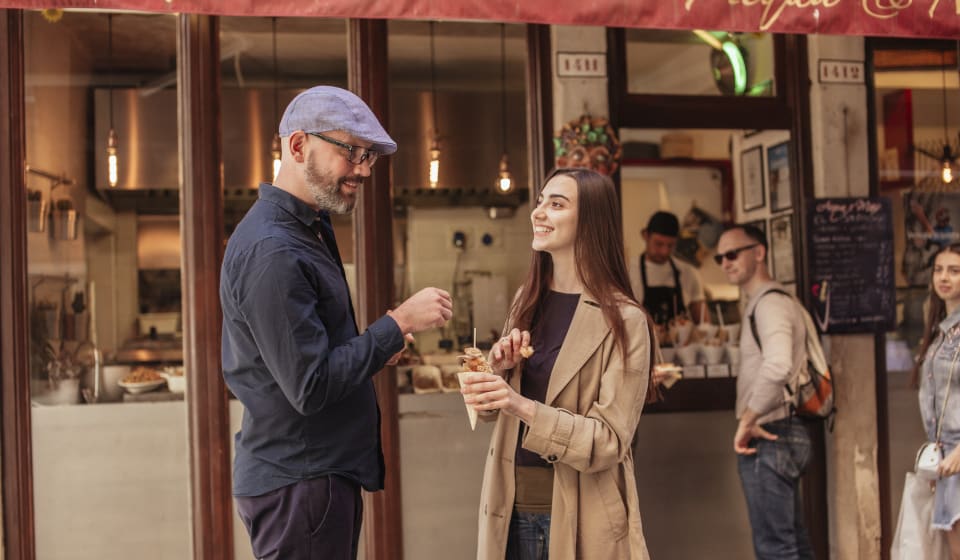 A local guide sharing a tasting of food in Venice with a tourist