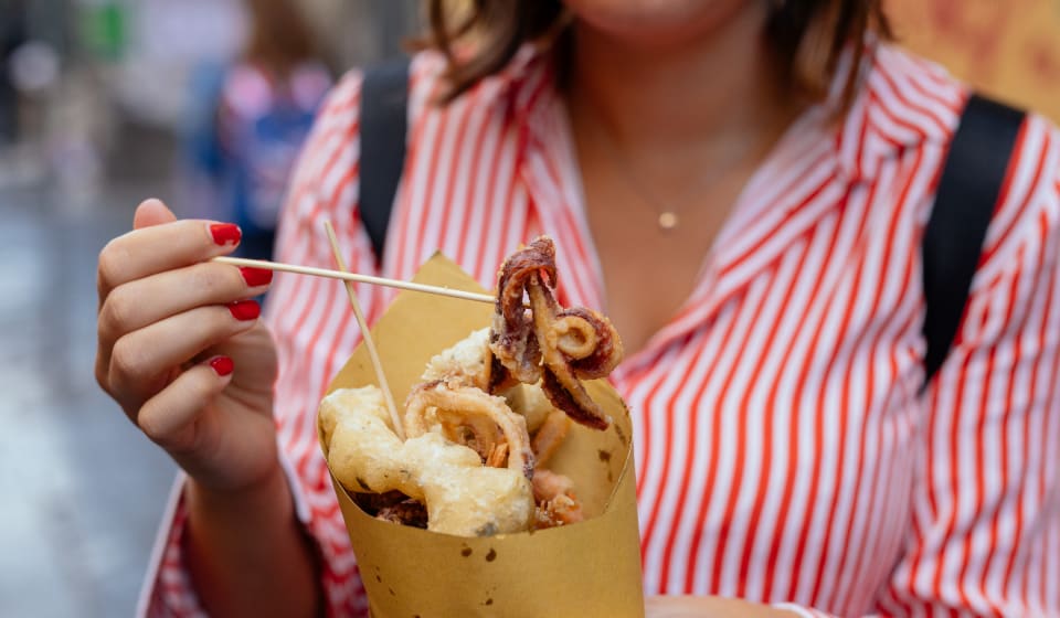 A tourist showing a sea food snack from a market in Naples