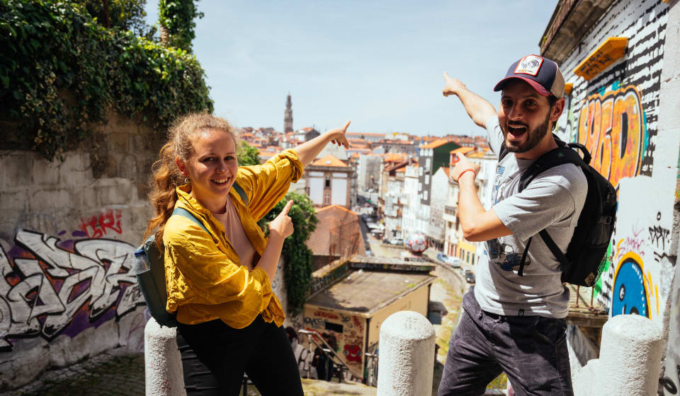 A local guide and a tourist posing in front of a view of Port at one of the Miradouros