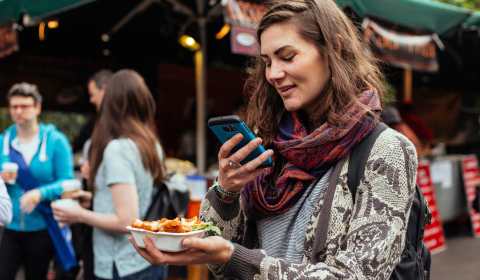A tourist making a picture of a local English snack at a food market in London