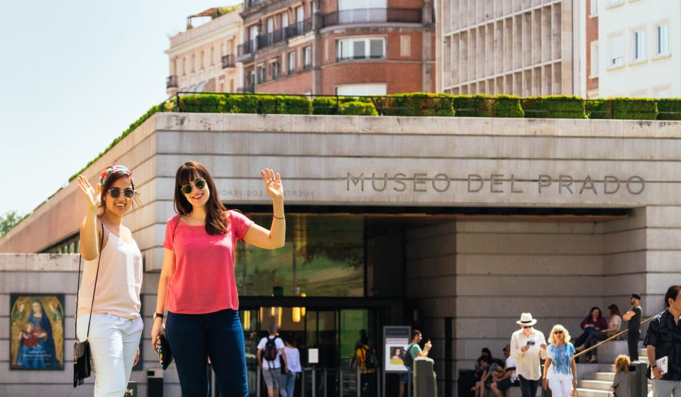 A local guide and tourist waving in front of the Museo del Prado in Madrid