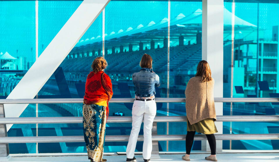 Three girls looking through a blue tainted window