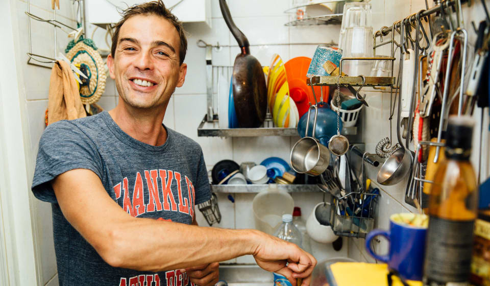 An Italian local host cooking in the kitchen a home dinner in Milan