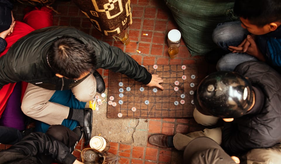 Top down view of people playing a Vietnamese chess-like game