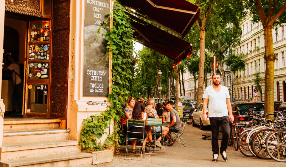 A corner of a bar in Berlin with people sitting outside on a terrace