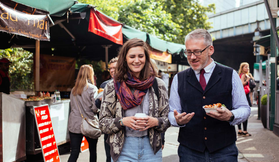 A local guide with a tourist with some street food in San Francisco