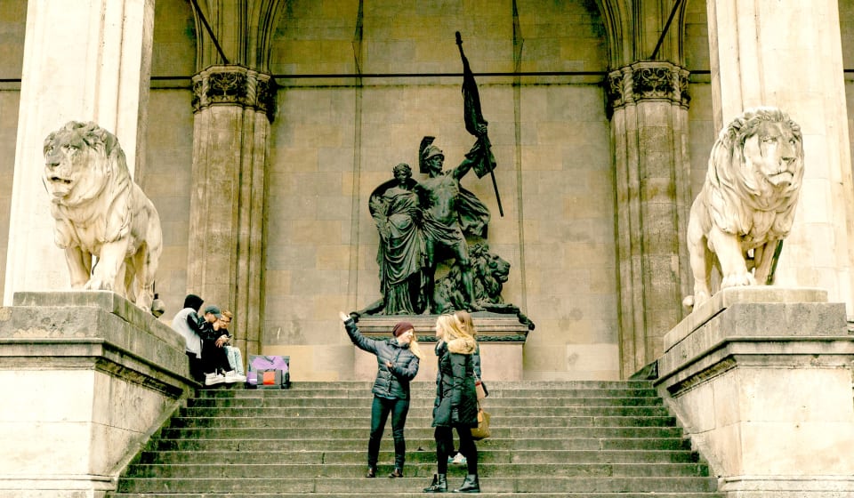 Two people on stair with a statue in the background