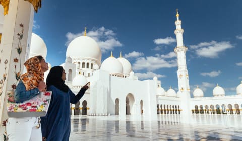 A local guide showing a tourist a mosque in the United Arab Emirates
