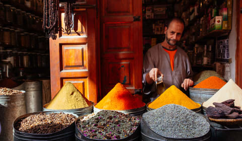 A market vendor showing spices at his market stall with various spices stalled