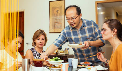 A local guide serving Taiwanese food to a group of tourists