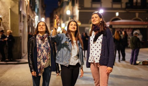 A local guide having two tourists on a private tour in the evening at the streets of Florence