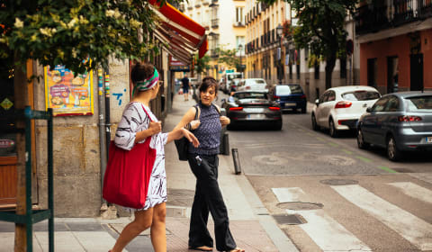 A local guide and tourist walking in a street in Madrid at the Embajadores district