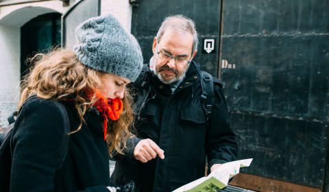 A local guide showing a map of Antwerp to a tourists