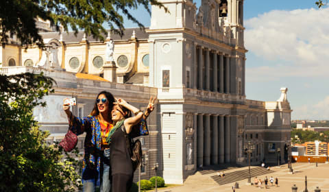 Two tourists making a picture at Catedral de la Almudena in Madrid