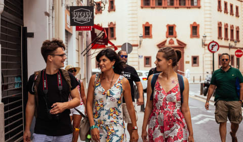 Local guide with two tourist walking in calle Colón in Valencia