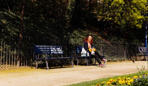A lady sitting in the park on a bench