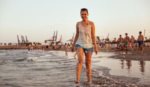 A woman walking in the water on Malvarrosa beach