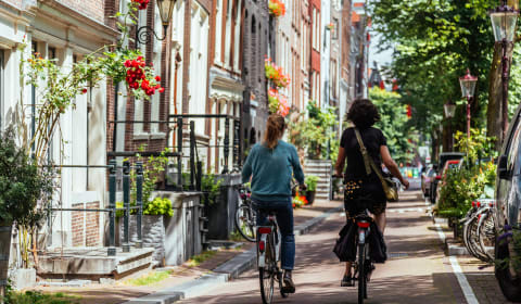 Two locals biking in Amsterdam