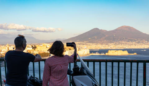 A local guide showing a tourist a view on Naples and Mount Vesuvius