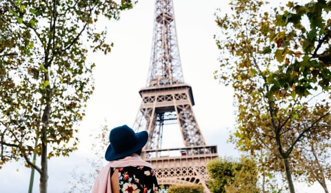 A woman from the back looking at the Eiffel tower in Paris