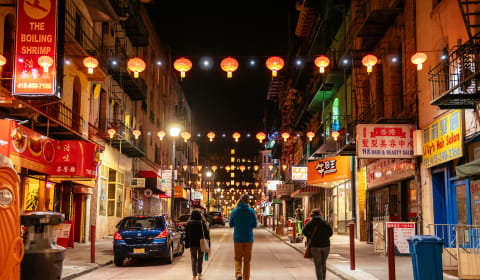 Three people walking on an empty street in China Town in San Francisco
