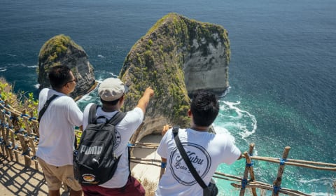 A local guide showing two tourists a beautiful cliff side on Bali